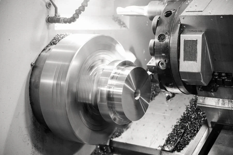 A metal workpiece being machined on a lathe