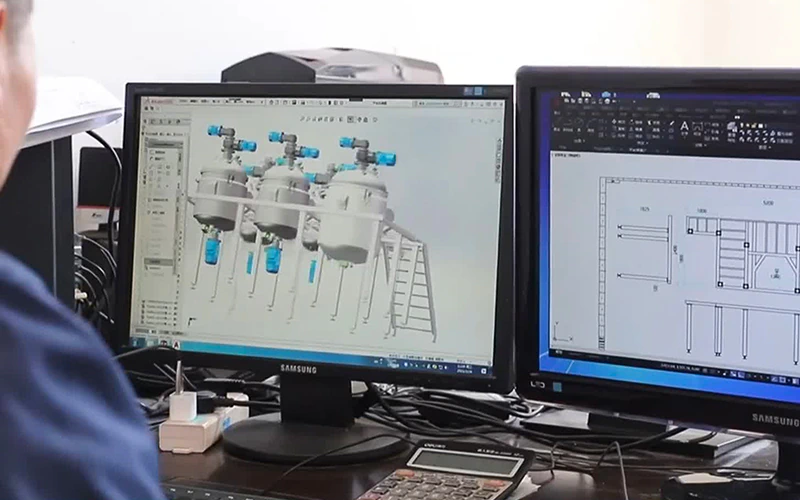 Vacuum emulsifying mixer model and layout shown on computer screens.